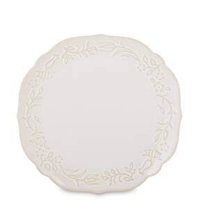 Krémový okrúhly porcelánový tanier s reliéfnym kvetinovým vzorom na bielom pozadí.