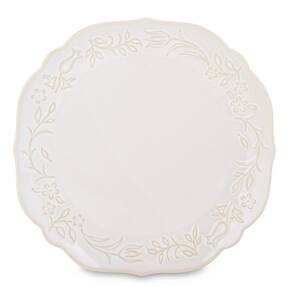veľký krémový okrúhly porcelánový tanier s reliéfnym kvetinovým vzorom na bielom pozadí.
